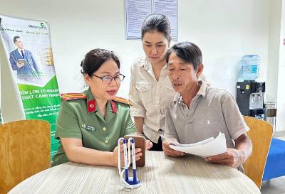 Cán bộ Phòng Hồ sơ (Công an tỉnh Đồng Nai) hướng dẫn người dân khai báo cấp phiếu lý lịch tư pháp. Ảnh: TTXVN phát