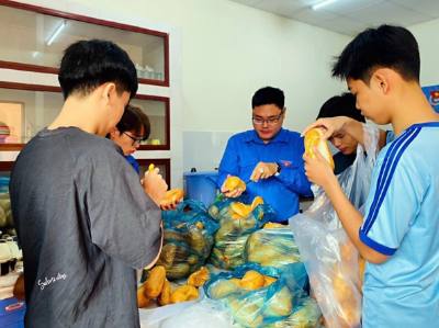 Anh Lại Phước Trường Thành (giữa), Bí thư Đoàn phường Cái Khế, quận Ninh Kiều cùng các tình nguyện viên nấu cơm miễn phí cho bệnh nhân có hoàn cảnh khó khăn tại mô hình "Bếp ấm". Ảnh: TTXVN phát
