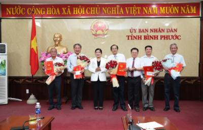 Lãnh đạo UBND tỉnh Bình Phước trao quyết định và tặng hoa chúc mừng các cán bộ lãnh đạo nghỉ hưu theo chế độ. Ảnh: Đậu Tất Thành - TTXVN