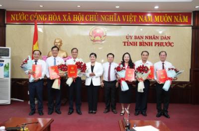 Lãnh đạo UBND tỉnh Bình Phước trao quyết định và tặng hoa chúc mừng các cán bộ lãnh đạo nghỉ hưu theo chế độ. Ảnh: Đậu Tất Thành - TTXVN