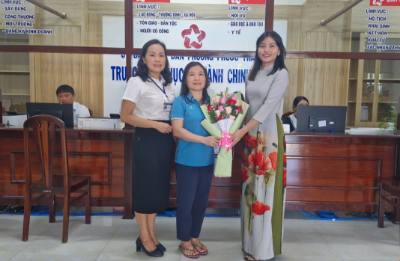 Cán bộ phường Phước Thắng, Thành phố Hồ Chí Minh tặng hoa cho người dân đến làm thủ tục hành chính đầu tiên trong ngày 1/7. Ảnh: Hoàng Nhị - TTXVN