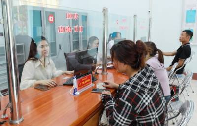 Cán bộ Trung tâm phục vụ hành chính công hướng dẫn người dân đến làm các thủ tục hành chính. Ảnh: Quý Trung – TTXVN