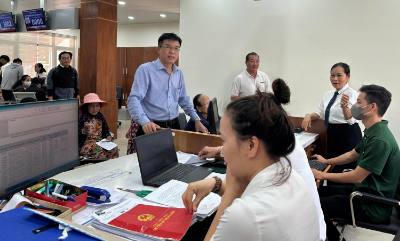 Cán bộ Trung tâm hành chính công phường Tam Kỳ, thành phố Đà Nẵng, hướng dẫn người dân làm thủ tục hành chính. Ảnh: Trần Tĩnh - TTXVN 