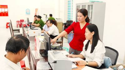 Cán bộ, công chức Trung tâm phục vụ hành chính công phường Tân Ninh giải quyết thủ tục hành chính cho người dân trong ngày đầu vận hành bộ máy chính quyền địa phương 2 cấp. Ảnh: Minh Phú - TTXVN