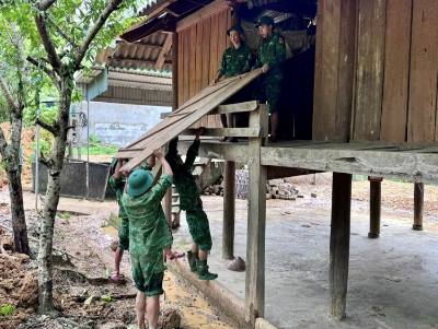 Cán bộ, chiến sĩ Đồn biên phòngThông Thụ (Nghệ An) giúp người dân địa phương khắc phục hậu quả sau lũ. Ảnh: TTXVN phát