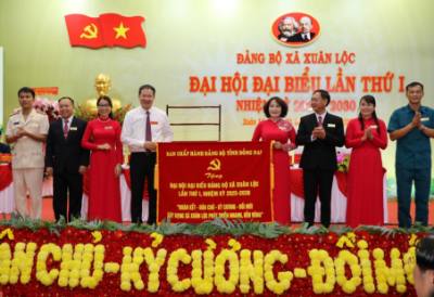 Bí thư Tỉnh ủy Vũ Hồng Văn trao bức trướng của Ban chấp hành Đảng bộ tỉnh Đồng Nai tặng và chúc mừng Đại hội Đảng bộ xã Xuân Lộc. Ảnh: Sỹ Tuyên - TTXVN