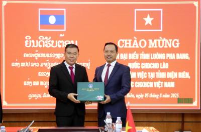 Phó Bí thư Tỉnh ủy Điện Biên Trần Tiến Dũng (phải) tặng quà lưu niệm đồng chí Sụ Căn Bun Nhông, Phó Bí thư Tỉnh ủy Luông-pha-bang. Ảnh: Trung Kiên - TTXVN