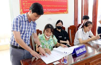 Cán bộ Trung tâm phục vụ hành chính công xã Quỹ Nhất, tỉnh Ninh Bình hướng dẫn người dân thực hiện các thủ tục hành chính. Ảnh: Nguyễn Lành - TTXVN 
