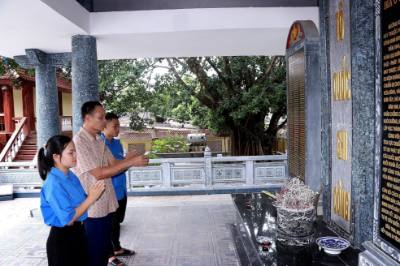 Thế hệ trẻ tri ân các liệt sĩ tại Bia Nhà truyền thống Mường Khói. Ảnh: Thanh Hải - TTXVN 