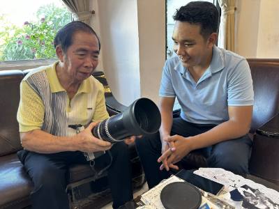 Nhà báo Trần Xuân Quang chia sẻ về chiếc máy ảnh đã theo ông từ những ngày đầu làm việc tại TTXVN. Ảnh: Khoa Chương - TTXVN