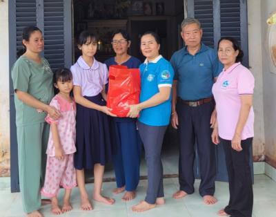 "Mẹ đỡ đầu" Đào Thị Liên (thứ 4, từ trái sang), ngụ xã Ngãi Giao, cùng đại diện Hội Liên hiệp Phụ nữ xã Ngãi Giao trao quà cho trường hợp em nhỏ mồ côi cha. Ảnh: Hoàng Nhị - TTXVN.