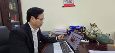 Tiến sĩ Nguyễn Đình Hoàng nghiên cứu thông tin về Đại hội Đại biểu toàn quốc lần thứ XIV của đảng trên website của Thông tấn xã Việt Nam. Ảnh: Minh Thu - TTXVN