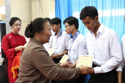 Bà Lê Minh Ngọc, nguyên Phó Giám đốc Sở Giáo dục và Đào tạo TP.Hồ Chí Minh, Phó Chủ nhiệm Câu lạc bộ "Vì Hoàng Sa - Trường Sa thân yêu" trao học bổng cho học sinh. Ảnh: Thanh Hòa - TTXVN