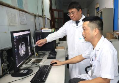 Bác sĩ chuyên khoa II Đoàn Lương Anh, Phó Giám đốc Bệnh viện Đa khoa tỉnh Tuyên Quang (người đứng) trao đổi chuyên môn trong quá trình chẩn đoán hình ảnh. Ảnh: Minh Tâm-TTXVN