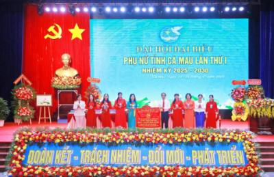 Phó Bí thư Tỉnh uỷ, Chủ tịch Ủy ban MTTQc Việt Nam tỉnh Cà Mau Hồ Thanh Thủy thay mặt Ban Chấp hành Đảng bộ tỉnh tặng bức trướng chúc mừng Đại hội. Ảnh: Huỳnh Anh - TTXVN