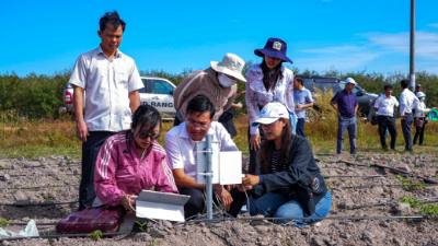 Giám đốc Sở Nông nghiệp và Môi trường tỉnh Tây Ninh Võ Minh Thành (ngồi giữa) khảo nghiệm trạm quan trắc dinh dưỡng đất tại cánh đồng sắn lớn ở xã Tân Hội, tỉnh Tây Ninh. Ảnh: Minh Phú – TTXVN