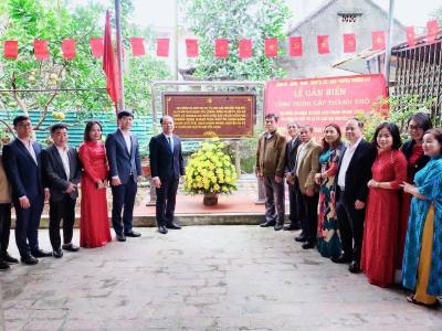 Lãnh đạo phường Thượng Cát thực hiện nghi thức gắn biển tại gia đình cụ Ngô Thị Cọ và con gái Nguyễn Thị Đúc. Ảnh: Nguyễn Cúc-TTXVN