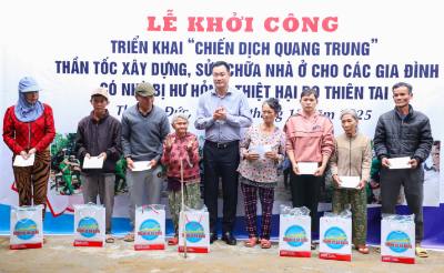 Bí thư Thành ủy Đà Nẵng Lê Ngọc Quang (giữa) tặng quà cho các gia đình bị thiệt hại do thiên tai tại lễ khởi công nhà ở theo “Chiến dịch Quang Trung”. Ảnh: TTXVN