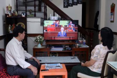 Người dân Đà Nẵng theo dõi phiên khai mạc Đại hội đại biểu toàn quốc lần thứ XIV qua truyền hình trực tiếp. Ảnh: Trần Lê Lâm - TTXVN 