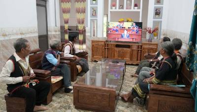 Già làng, người có uy tín và bà con làng Plei Jơ Drơp, xã Ia Chim, tỉnh Quảng Ngãi theo dõi phiên khai mạc Đại hội lần thứ XIV của Đảng. Ảnh: Cao Nguyên - TTXVN