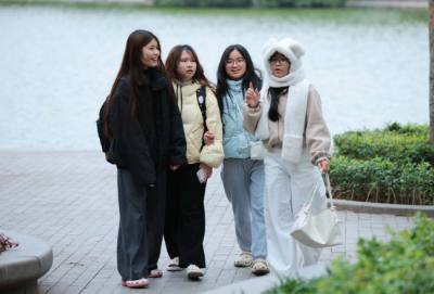 Người dân ra đường đều mặc áo ấm, khăn quàng cổ để đảm bảo sức khoẻ khi phải ra ngoài trời. Ảnh: Hoàng Hiếu - TTXVN