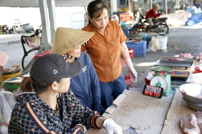 Tiểu thương tại chợ Phú Thủy (phường Phú Thủy, tỉnh Lâm Đồng) theo dõi phiên bế mạc Đại hội đại biểu toàn quốc lần thứ XIV của Đảng. Ảnh: Nguyễn Thanh - TTXVN